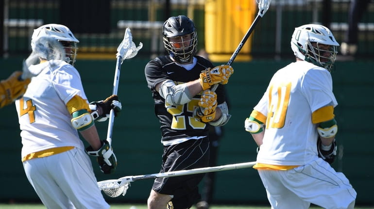 Adelphi attacker Salvatore Tuttle follows through on his shot and...