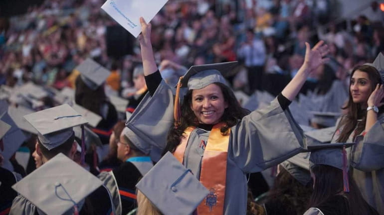 A graduate waves during Nassau Community College's Fifty Second Commencement...
