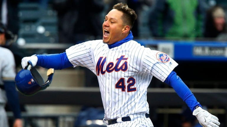 Wilmer Flores of the Mets celebrates his ninth inning walk...