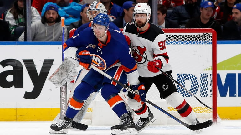 Adam Pelech #3 of the New York Islanders defends the...