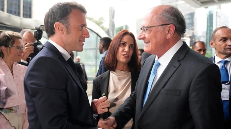 France's President Emmanuel Macron, left, shakes hands with Brazil's Vice...