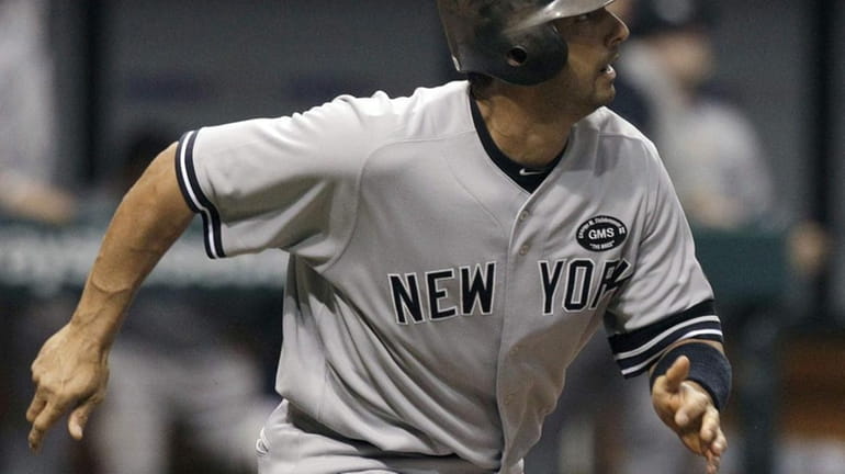 New York Yankees' Jorge Posada watches his 10th-inning home run...