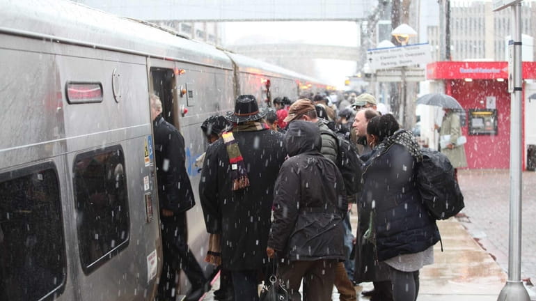 Commuters dodge snowflakes at the Mineola LIRR station in Mineola....
