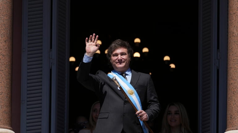 Argentina's newly sworn-in President Javier Milei waves to supporters from...