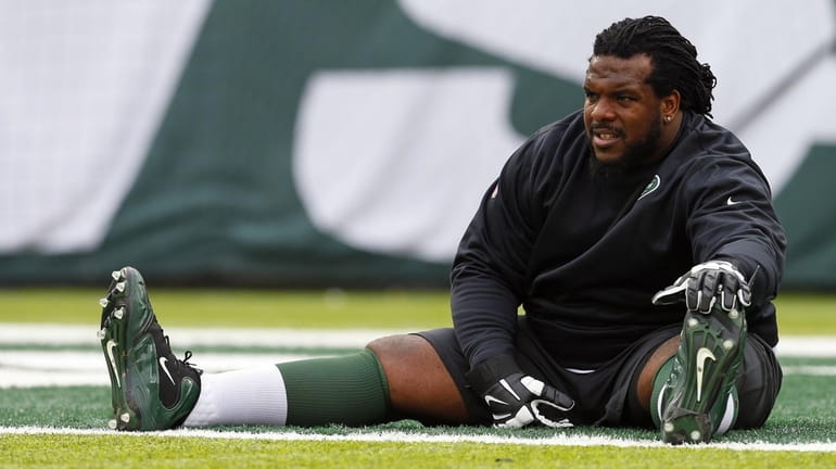 Guard Willie Colon of the New York Jets streaches before...