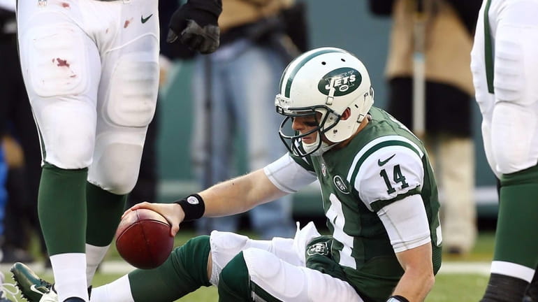 Greg McElroy #14 of the New York Jets gets up...