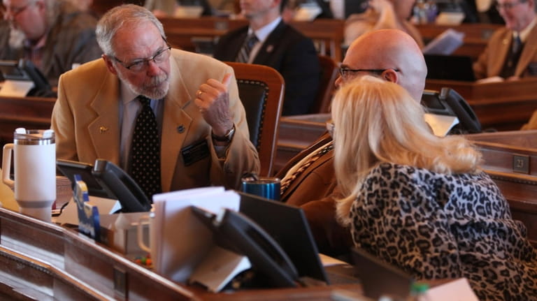 Kansas state Rep. Will Carpenter, left, R-Winfield, confers with two...