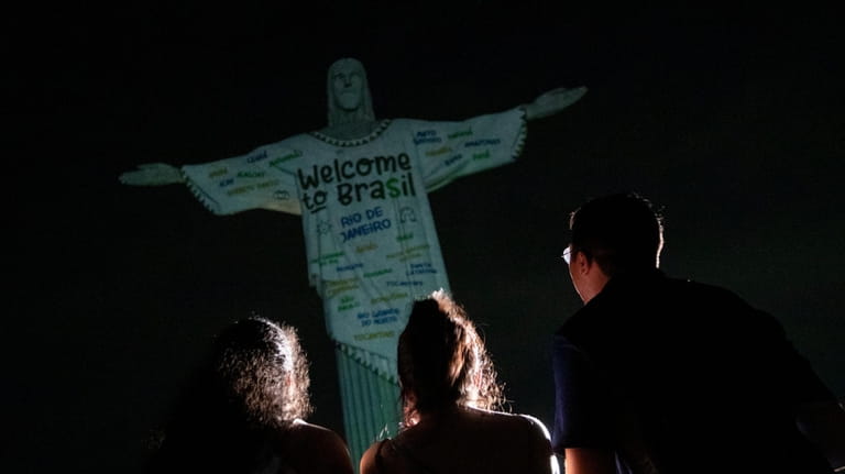 Fans look up at the Christ the Redeemer statue that...