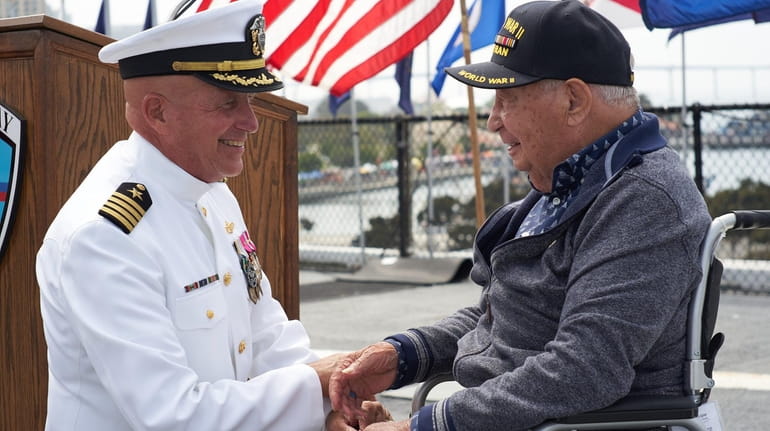 Retired Capt. Steve Gilmore greets William Gomez, right, who was honored...