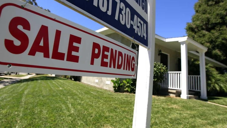 A sale pending sign is seen outside a home in...