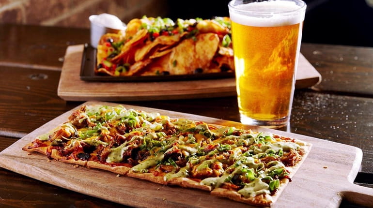 A flatbread topped with barbecued duck, poblano chilies, Cheddar and...