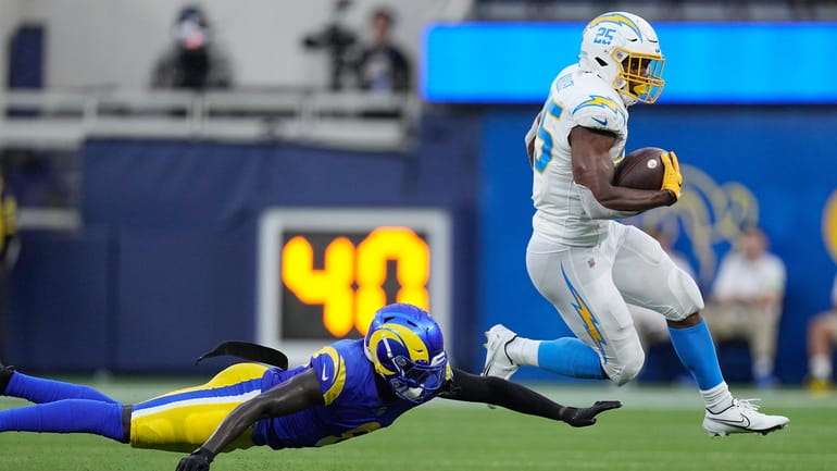 Los Angeles Chargers running back Joshua Kelley, right, jumps past...