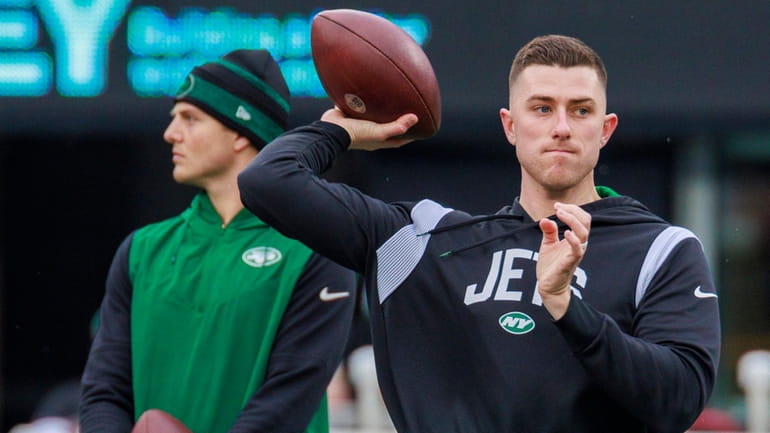 Jets quarterback Mike White warms up in front of Zach...