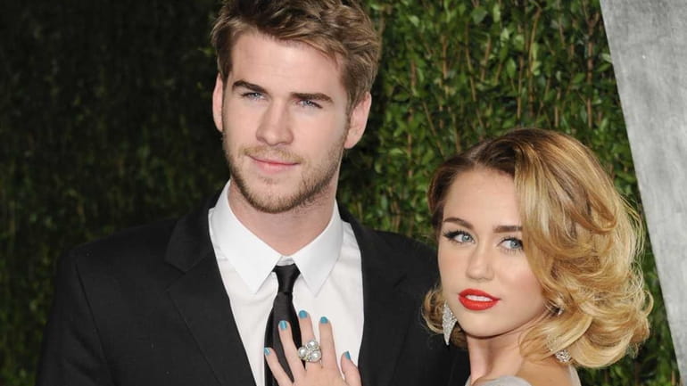 Miley Cyrus, right, and Liam Hemsworth at the Vanity Fair...