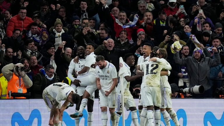 Real Madrid players celebrate after teammate Karim Benzema scored their...