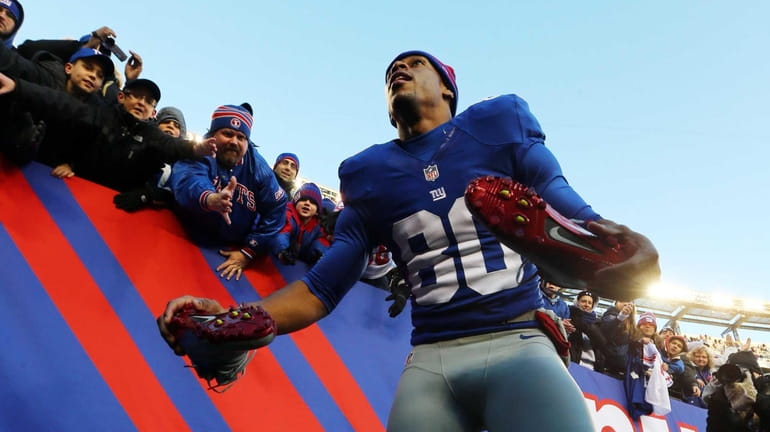 Victor Cruz takes off his shoes to give to fans...