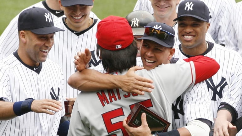 Los Angeles Angels' Hideki Matsui, center, is embraced by former...