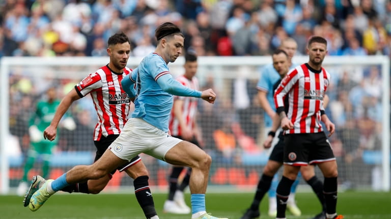 Manchester City's Jack Grealish, foreground, controls the ball during the...