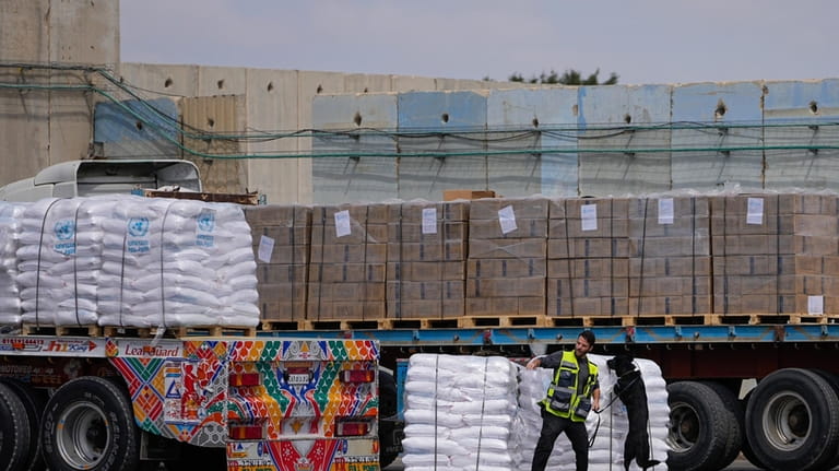 Trucks carrying humanitarian aid for the Gaza Strip pass through...