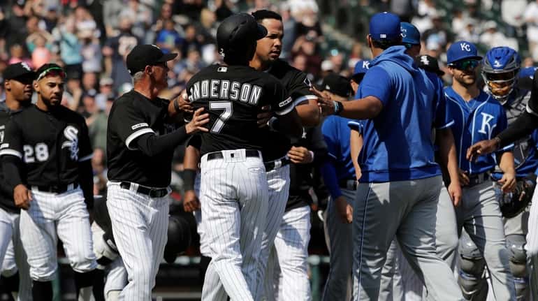 The White Sox's Tim Anderson is restrained by Jose Abreu...