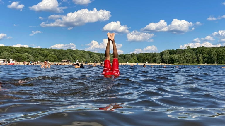 People swim in a lake at Harriman State Park in...