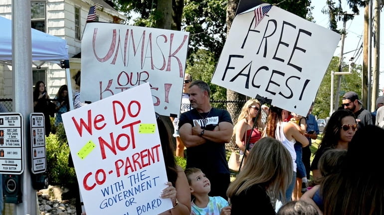 Smithtown residents rallied against masks in schools outside the administrative...