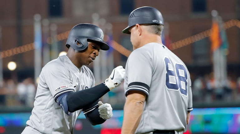 Yankees shortstop Didi Gregorius is congratulated by third base coach...