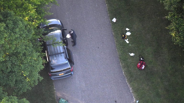Crime scene investigators on Thursday inspect the minivan abandoned in...