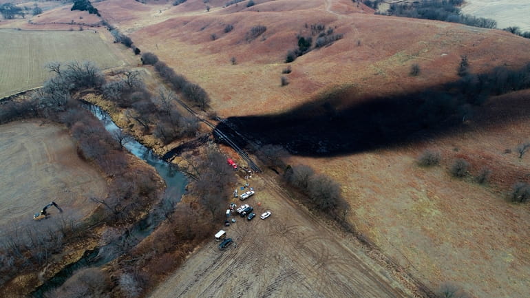 In this photo taken with a drone, cleanup continues in...