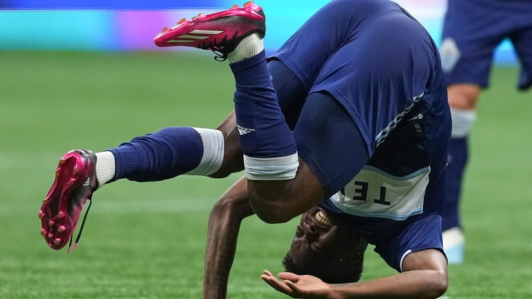 Vancouver Whitecaps' Javain Brown tumbles to the ground after colliding...
