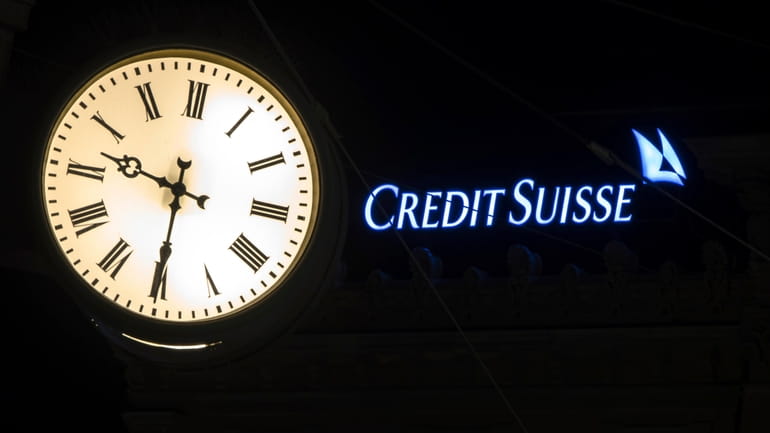 The illuminated logo of Swiss bank Credit Suisse is seen...