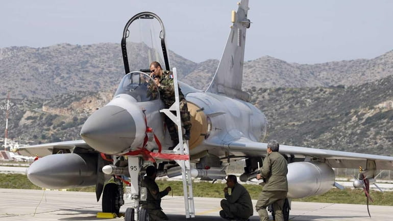 Qatar and French Air Force ground crew prepare a Mirage...