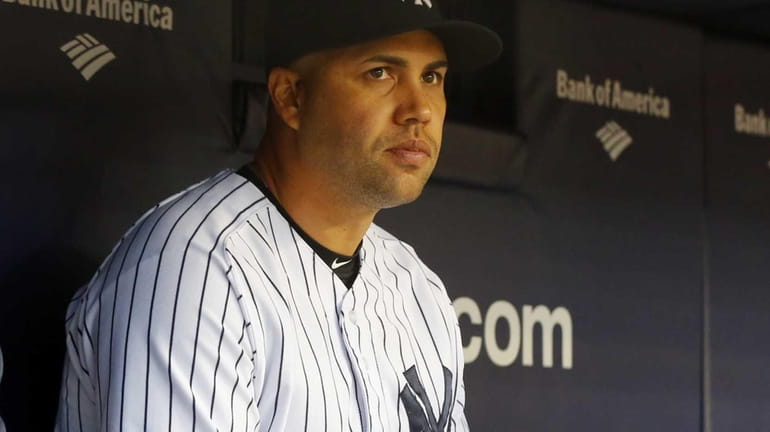 The Yankees' Carlos Beltran looks on from the dugout during...