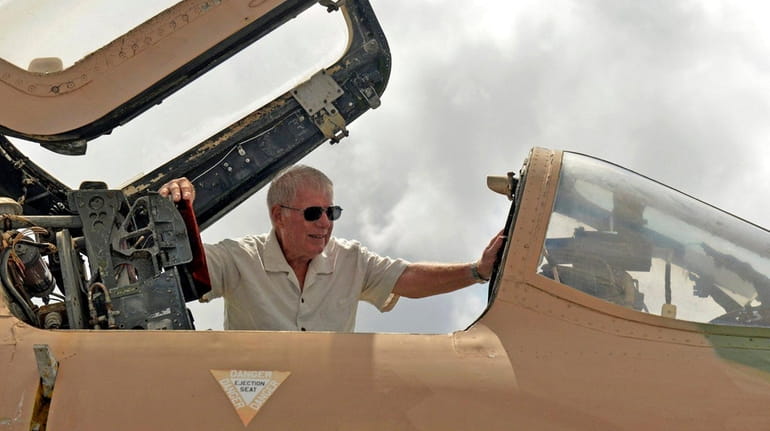 Retired Air Force Colonel Fred Claussen looks into the cockpit...