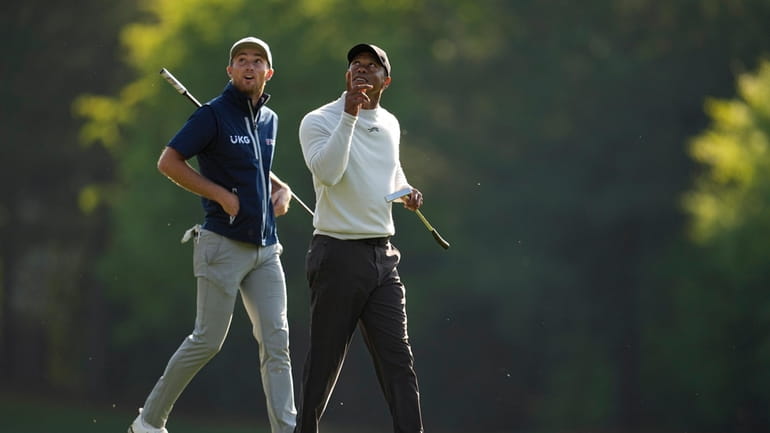 Will Zalatoris, left, and Tiger Woods walk to the12th green...
