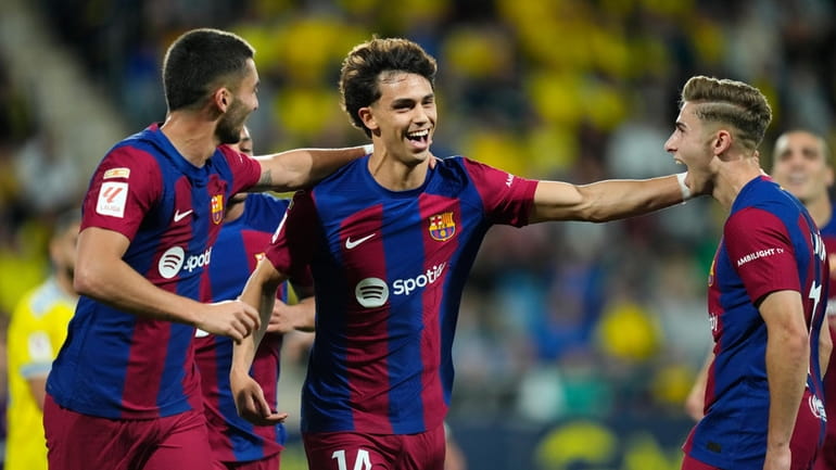Barcelona's Joao Felix, center, celebrates after scoring the opening goal...