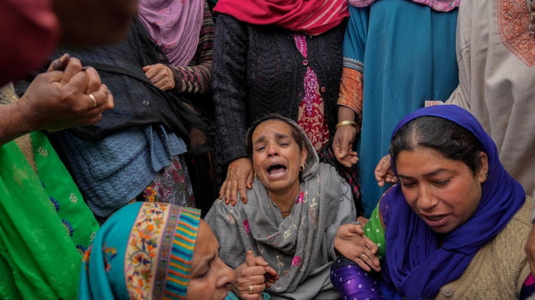 Family members and relatives cry after a boat carrying people...