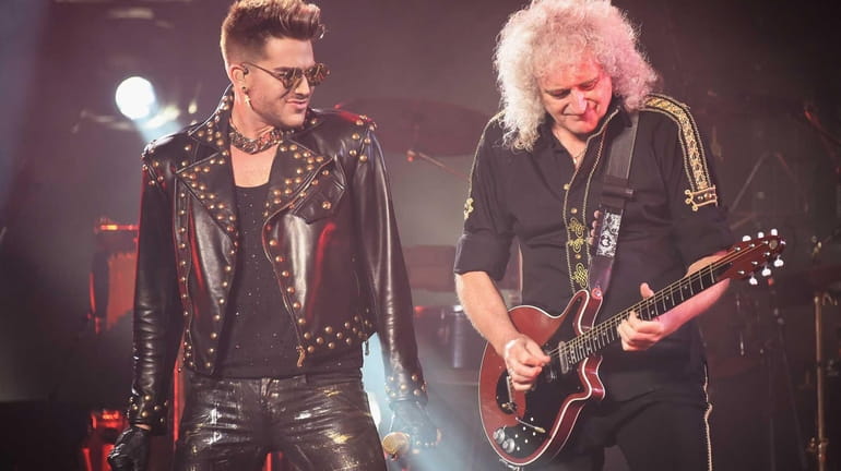 Singer Adam Lambert, left, performs with guitarist Brian May of...