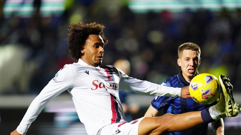 Bologna's Joshua Zirkzee, left, challanges for the ball during the...