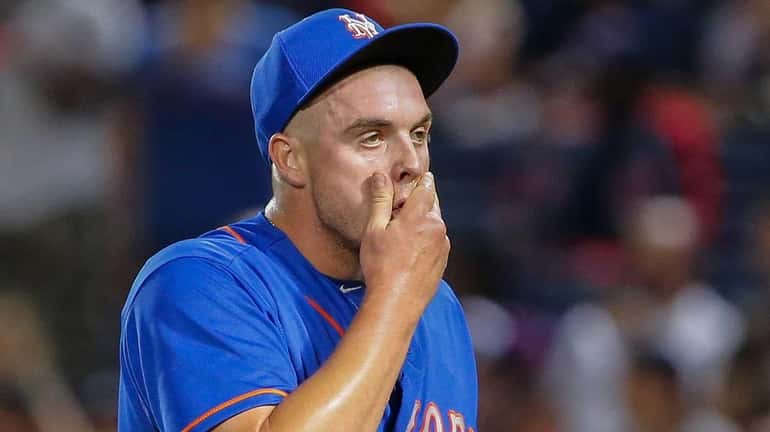 Mets relief pitcher Addison Reed walks off the field against...
