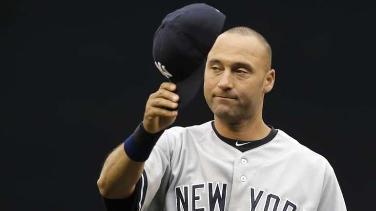 Yankees' Derek Jeter tips his cap to fans as he...