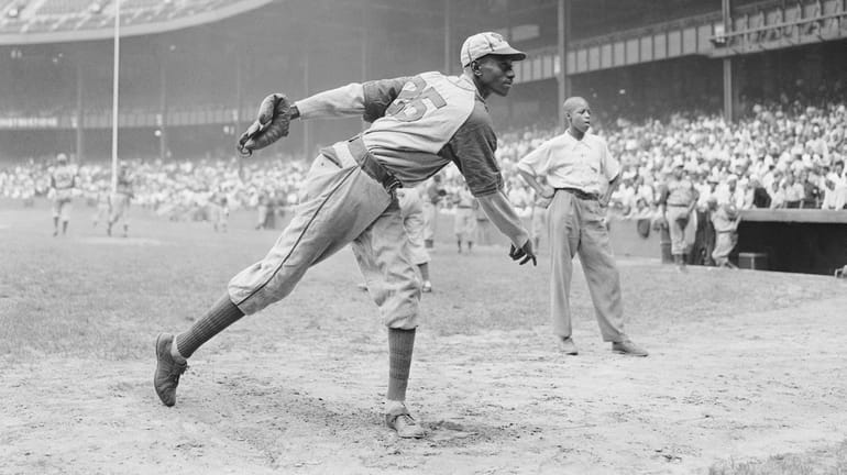 Kansas City Monarchs pitching great Leroy Satchel Paige warms up...