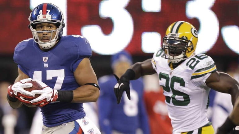 New York Giants' Travis Beckum, left, is chased by Green...