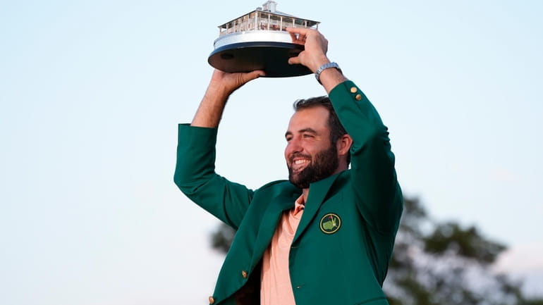 Scottie Scheffler holds the trophy after winning the Masters golf...