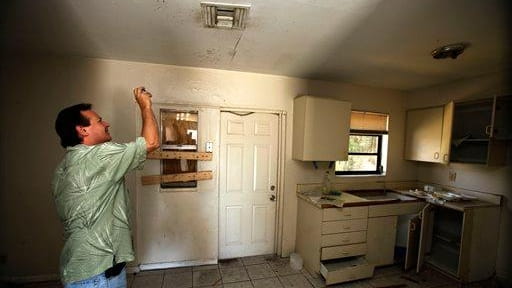 Frank Verna takes photos of a kitchen ceiling while checking...