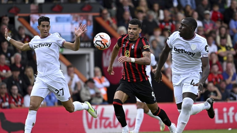 Bournemouth's Dominic Solanke battles for the ball with West Ham...