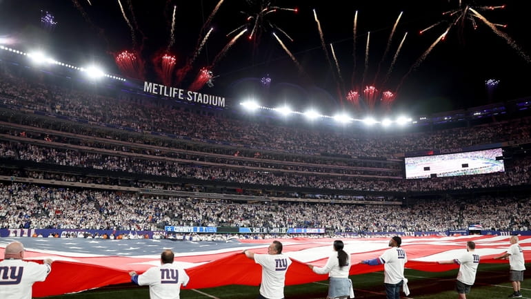 Fireworks explode over the stadium during the national anthem prior...
