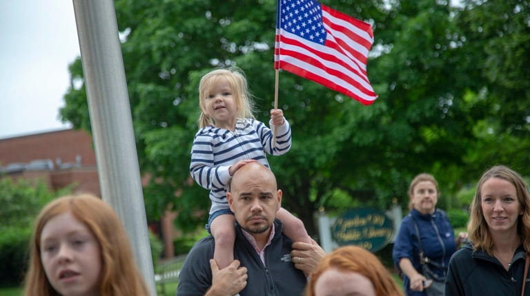 Charlotte Erb, 3, of West Hempstead, cheers on her father...