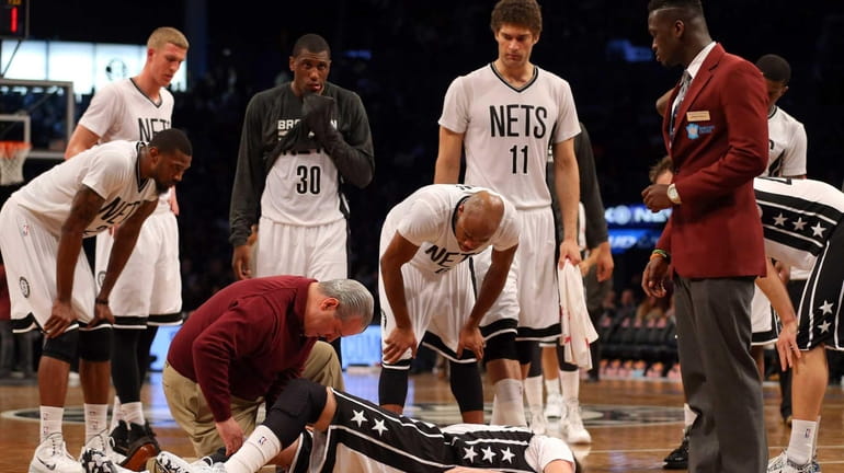 Brooklyn Nets' Sergey Karasev is attended to after injuring his...