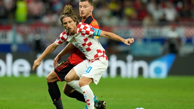 Croatia's Luka Modric, front, duels for the ball with Belgium's...
